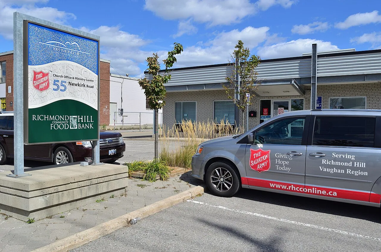The entrance and sign of a community food bank with a Salvation Army van parked out front (a food bank in Ontario, shown as a generic example)