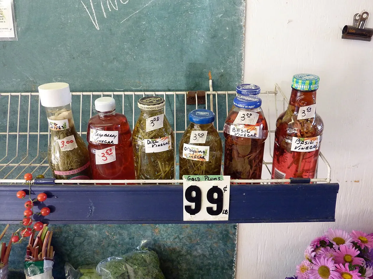 Jars of homemade preserves on a shelf at a farmers' market stall
