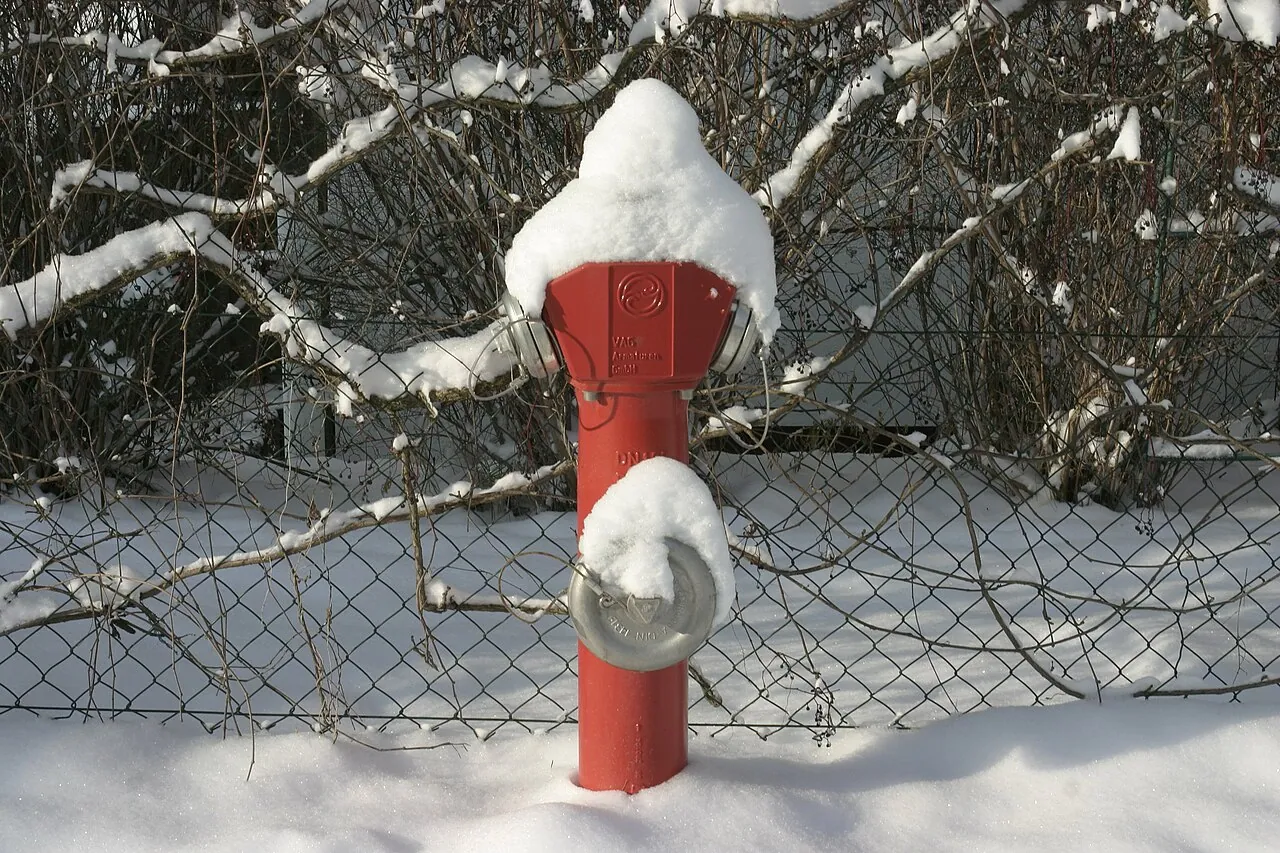 A red fire hydrant capped with snow