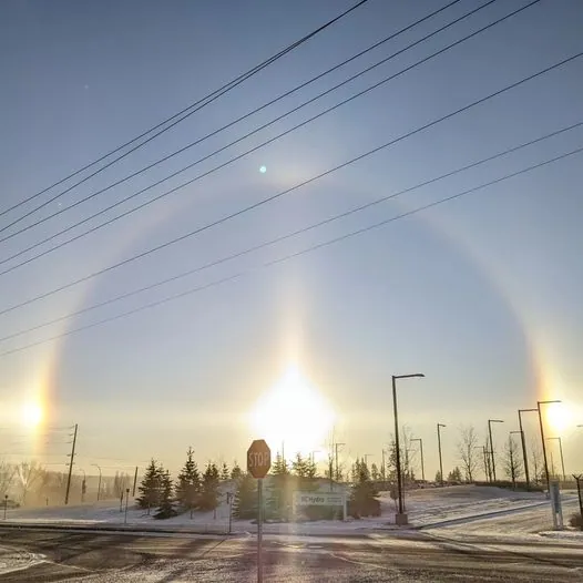 Sun dogs, bright spots of light on either side of the sun, over snowy Prince George on a very cold day