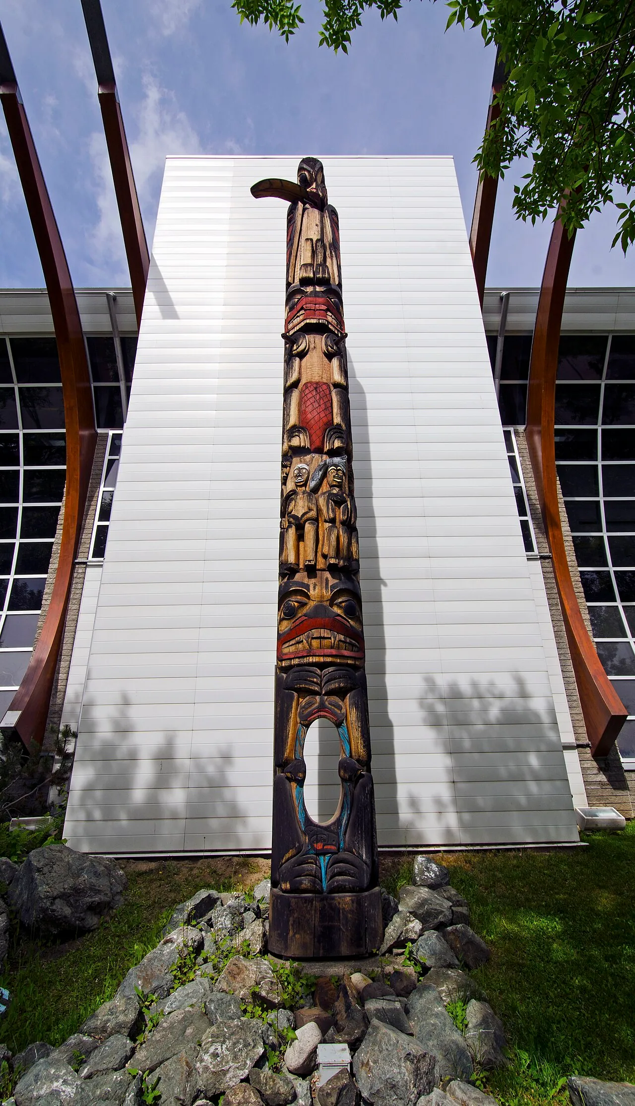 A tall carved and painted wooden pole standing outside a building in Prince George