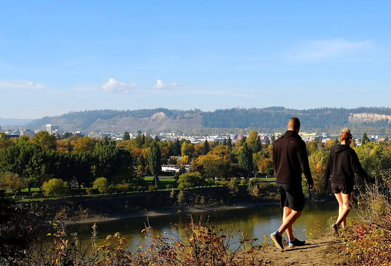 Two walkers on the LC Gunn Park trail looking over the Fraser River valley