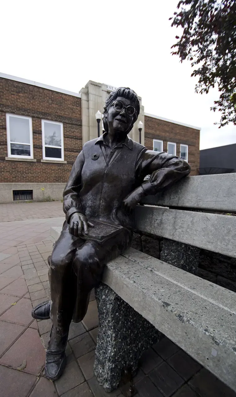 Carved statue of social worker and author Bridget Moran seated on a bench in Prince George