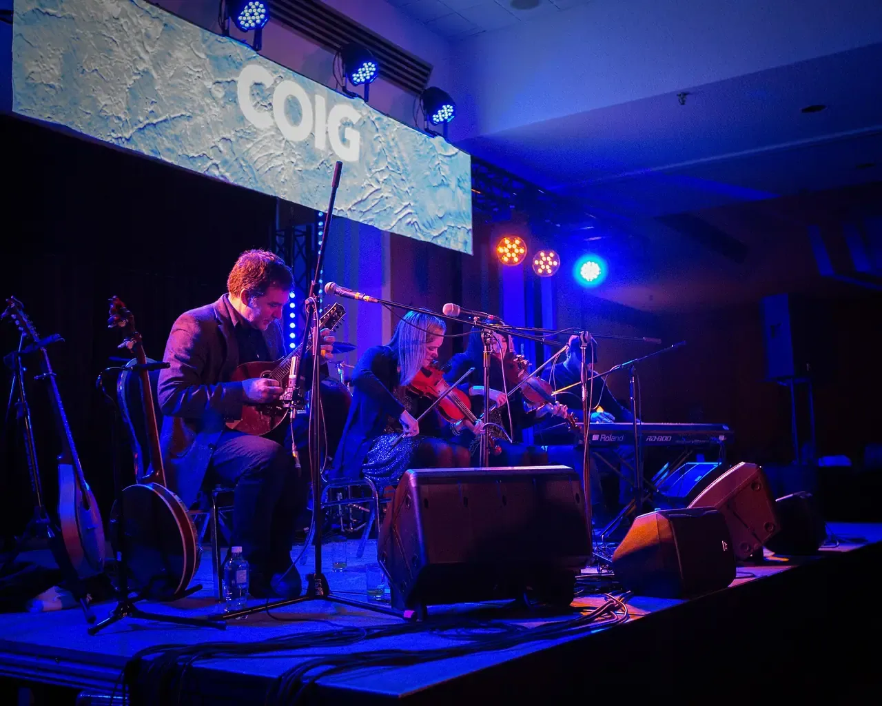 The band Còig performing under blue stage lights at the Coldsnap Festival in Prince George